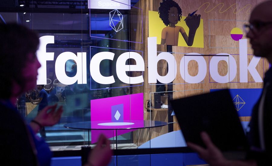 Conference workers speak in April in front of a demo booth at Facebook’s annual F8 developer conference in San Jose, Calif. Facebook blamed a technical glitch on Wednesday for knocking several Catholic-focused Facebook pages with millions of followers offline for more than a day.