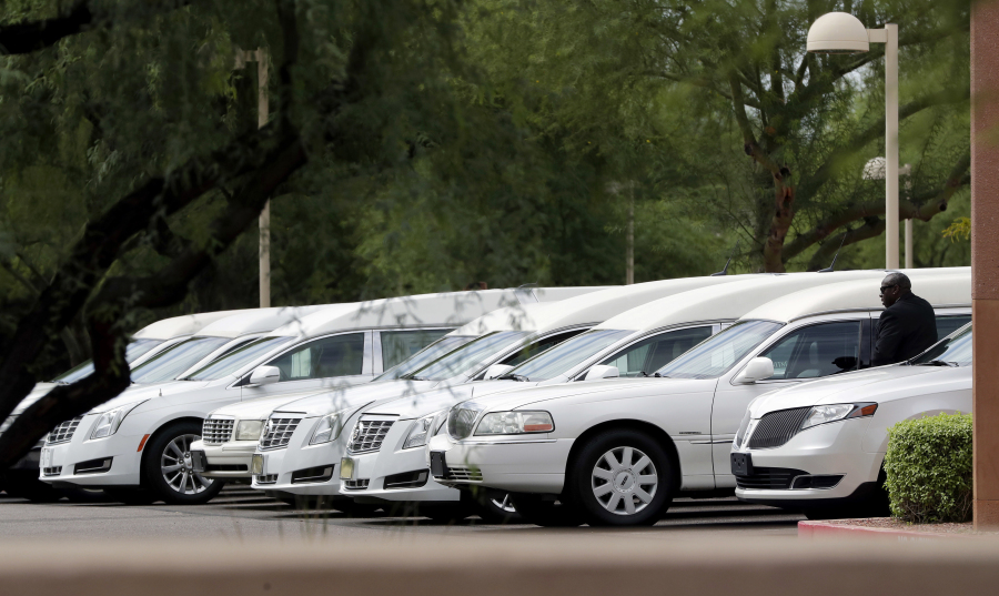 Hearses of the family members who were killed in a flash flood are parked outside St. Patrick church on Tuesday.