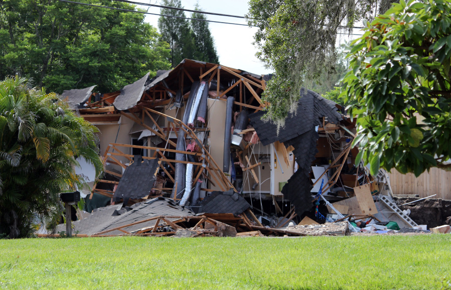 Debris is strewn about from a partially collapsed home in Land O' Lakes, Fla. on Friday, July 14, 2017.A sinkhole that started out the size of a small swimming pool and continued to grow has swallowed a home in Florida and severely damaged another.