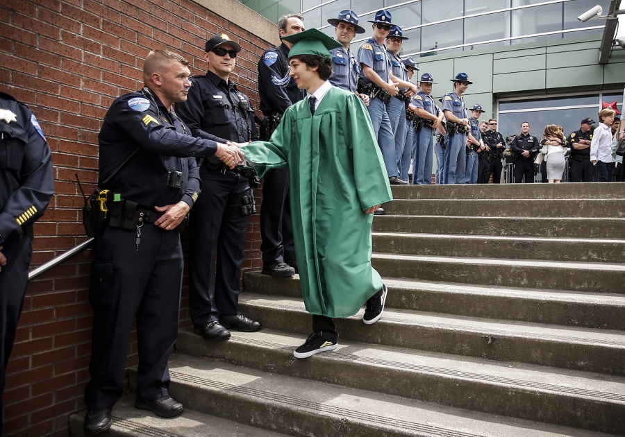 Woodinville High School graduate Esteban Underwood is greeted June 19 by Tulalip Police’s Jeff Jira along with many other law enforcement officers from various departments at his school’s graduation ceremony at Xfinity Arena in Everett.