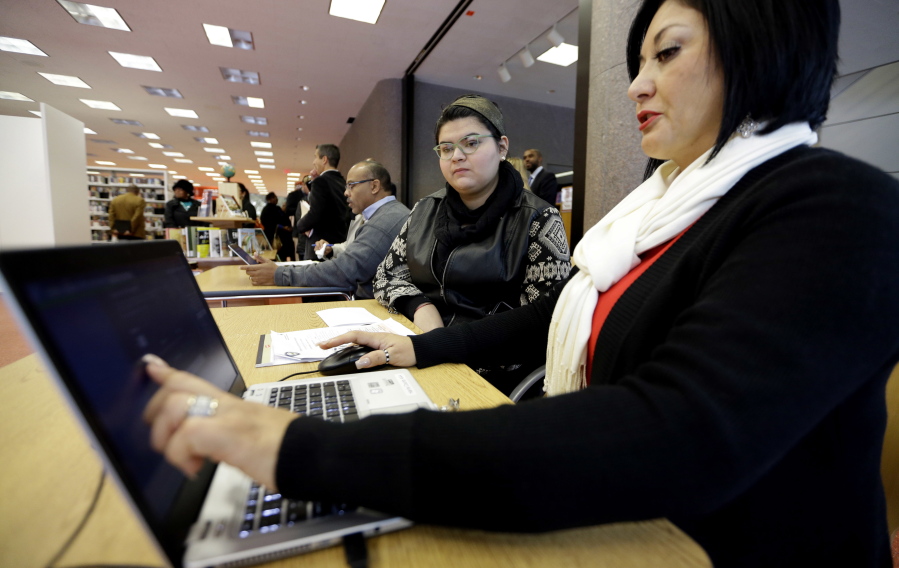 Affordable Care Act health insurance marketplace navigator Leticia Chaw, right, helps gather information for Jennifer Sanchez to re-enroll in a health insurance plan in Houston. Shoppers will have fewer places to turn for help signing up for coverage on the ACA’s insurance exchanges with the announcement in July 2017 that President Donald Trump’s administration ended contracts that brought assistance into libraries, businesses and urban neighborhoods in 18 cities. (AP Photo/David J.