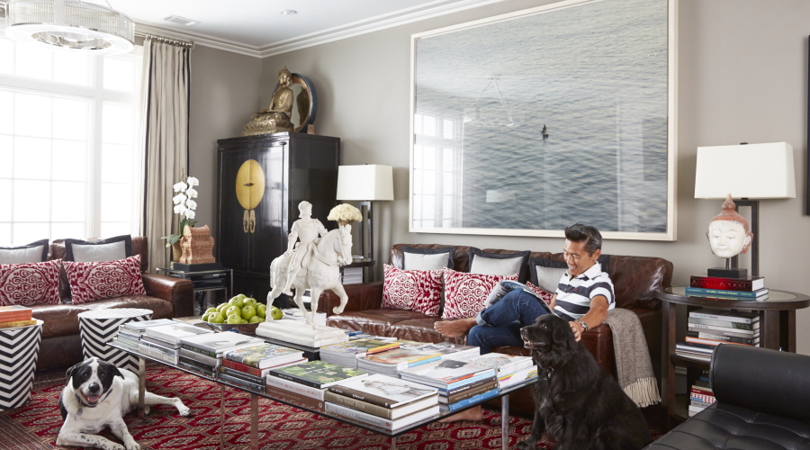 This undated photo provided by interior designer Vern Yip shows Yip sitting on a couch with his dogs in his home in Atlanta. With progress in technology, durable rugs made with antimicrobial, stain-resistant fibers have become much more pleasant to the touch and are available in a wide range of styles, making them perfect for pet owners, says Yip. (David A.