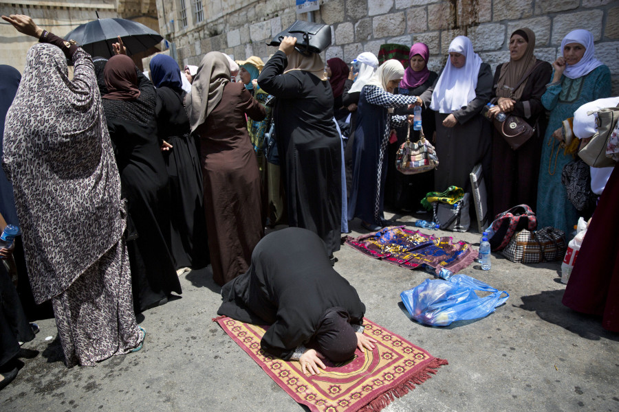 Palestinians women pray at the Lion’s Gate following an appeal from clerics to pray in the streets instead of inside the Al Aqsa Mosque compound, in Jerusalem’s Old City on Tuesday. Dozens of Muslims have prayed in the street outside a major Jerusalem shrine, heeding a call by clerics not to enter the site until a dispute with Israel over security arrangements is settled. This comes after Israel removed metal detectors earlier on Tuesday.
