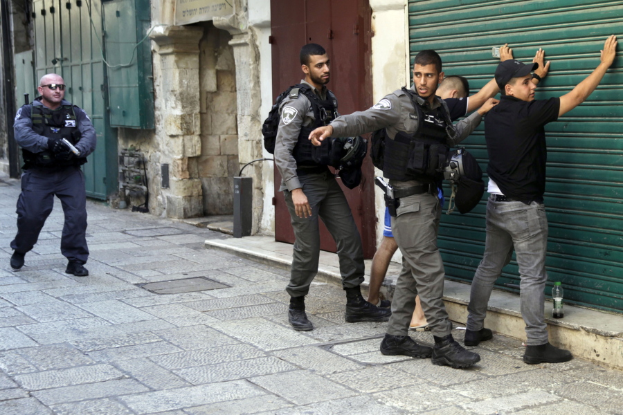 Israeli border police officers body-search Palestinians in Jerusalem’s Old City, Friday, July 14, 2017. Three Palestinian assailants opened fire on Israeli police from inside a major Jerusalem holy site Friday, killing two officers before being shot dead, police said.