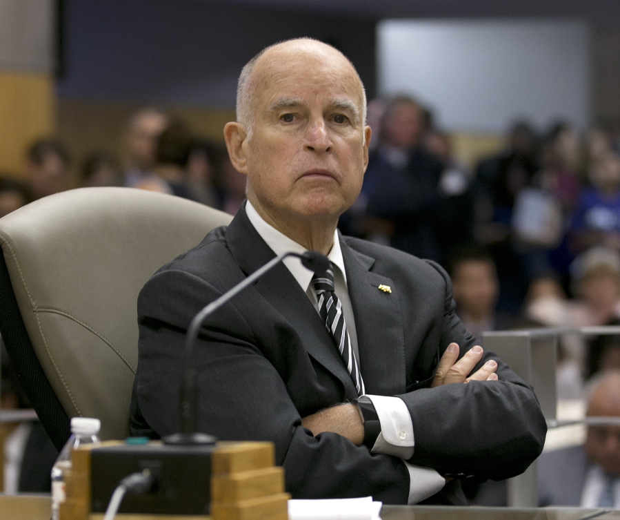 California Gov. Jerry Brown listens as members of the Senate Environmental Quality Committee discuss a pair of climate change bills he supports, in Sacramento, Calif.