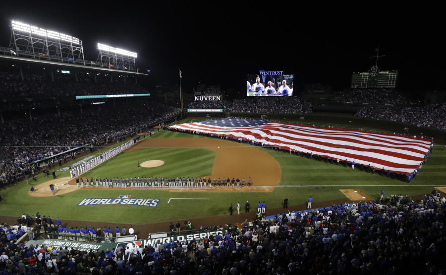 A giant United States flag is displayed during the national anthem before Game 3 of the Major League Baseball World Series between the Cleveland Indians and the Chicago Cubs in Chicago. The anthem has been a standard part of U.S. sports games since World War II. Experts say Game 1 of the 1918 World Series between the Boston Red Sox and the Chicago Cubs helped pave the way. The song became the official national anthem in 1931.