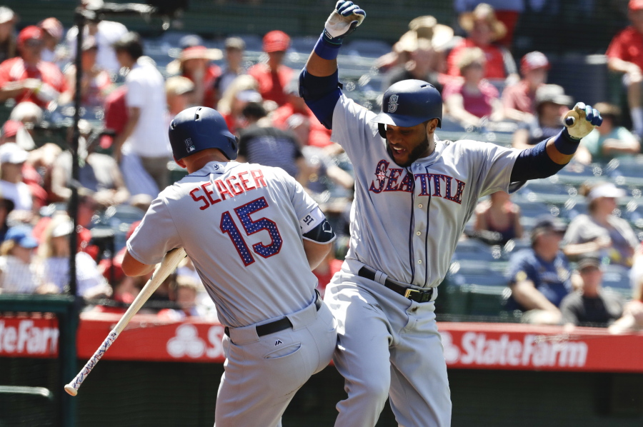 Seattle Mariners’ Robinson Cano, right, celebrates with Kyle Seager after his three-run home run during the eighth inning of a baseball game against the Los Angeles Angels in Anaheim, Calif., Sunday, July 2, 2017.