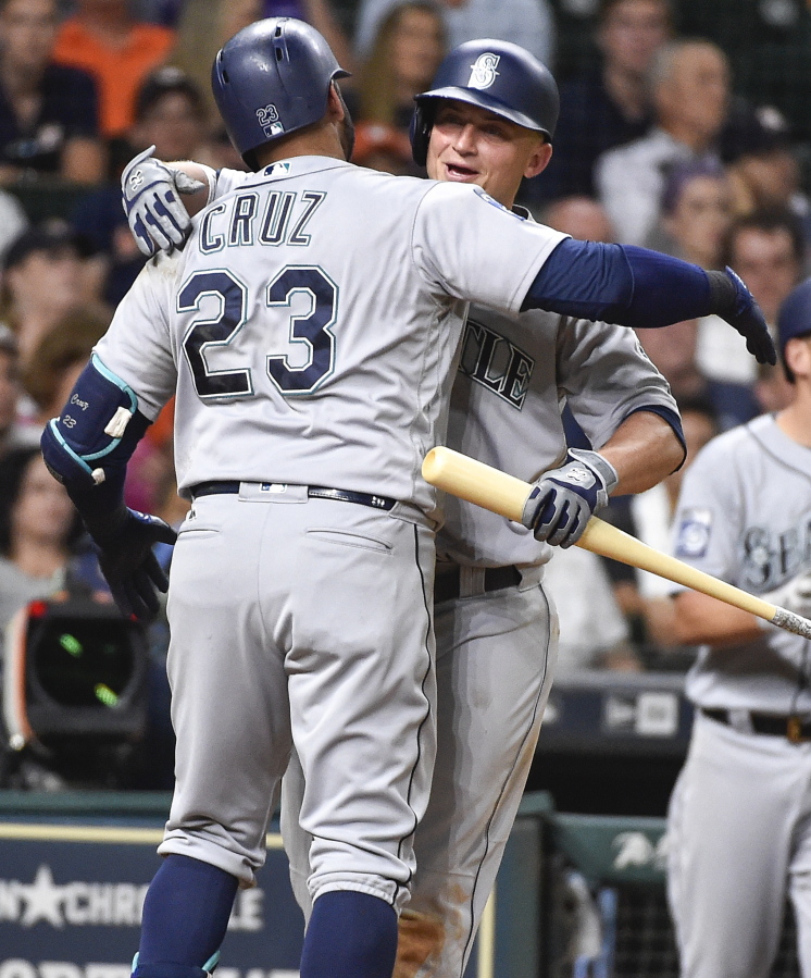 Seattle Mariners’ Nelson Cruz (23) hugs Kyle Seager after hitting a home run off Houston Astros relief pitcher Chris Devenski during the seventh inning of a baseball game, Monday, July 17, 2017, in Houston.