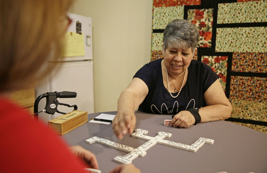 Cynthia Guzman plays dominoes at her home July 12 in Napa, Calif. Guzman underwent a special kind of PET scan that can detect a hallmark of Alzheimer’s and learned she didn’t have that disease as doctors originally thought, but a different form of dementia. New research suggests those scans may lead to changes in care for people with memory problems that are hard to diagnose.
