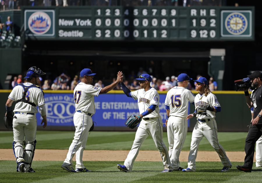 Seattle Mariners’ Leonys Martin, center right, and Hansel Robles (47) high-five after they defeated the New York Mets in a baseball game, Sunday, July 30, 2017, in Seattle. (AP Photo/Ted S.