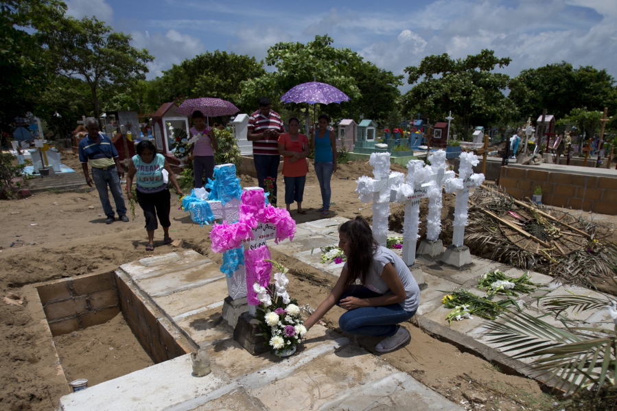 Aunts, uncles and grandparents place flowers and home-made concrete crosses atop the graves of the Martinez children, their mother and father at a cemetery in Coatzacoalcos, Veracruz State, Mexico. The family of six was massacred, authorities believe, because the hyper-violent Zetas cartel suspected the father, an unemployed taxi driver, had played some part in a rival gang’s attack that killed a Zeta gunman.