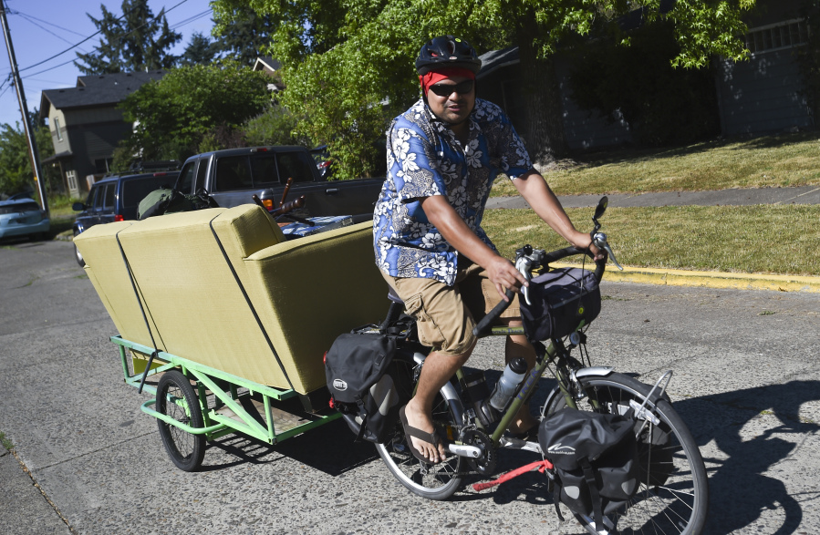 Fellow bicycle enthusiasts helped Sarah Bronstein and Corey McKrill to move from their two-bedroom rental to a newly purchased home on Northwest Mulkey Avenue on Sunday, July 23, 2017.