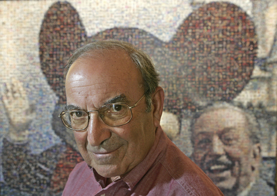 FILE - In this July 11, 2005 file photo, Martin “Marty” Sklar, Imagineering Vice Chairman and Principal Creative Executive, poses in front of a picture of Mickey Mouse and Walt Disney at Disneyland in Anaheim, Calif. Sklar, one of the central figures behind Disney’s theme parks around the world, has died. Sklar had a role in the opening of every Disney park, starting with the original Disneyland in 1955. A Disney statement said he died Thursday, July 27, 2017, at his Hollywood Hills home at age 83. (AP Photo/Jae C.