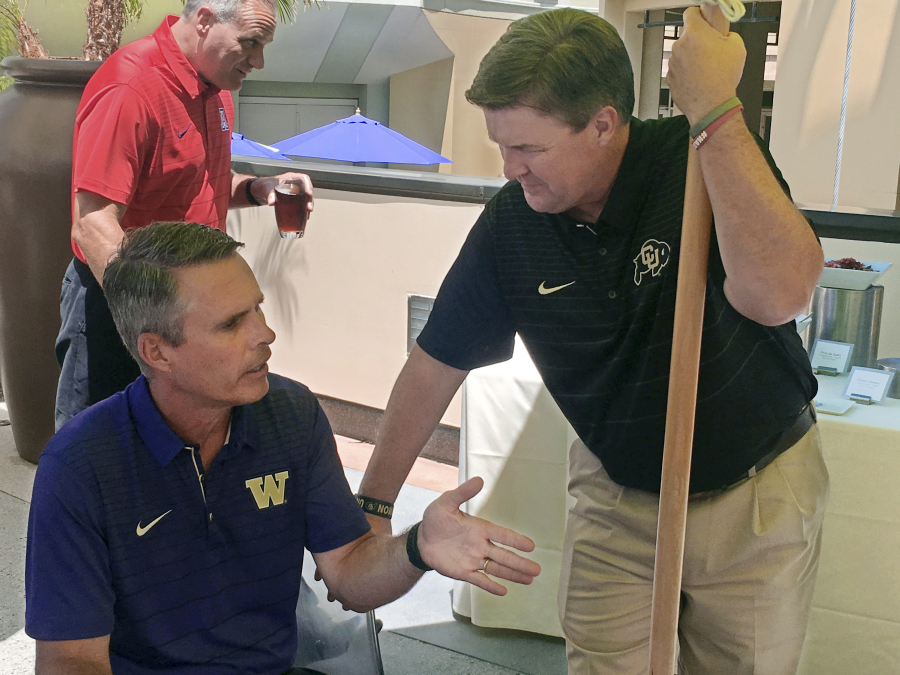 Washington coach Chris Petersen, left, and Colorado coach Mike MacIntyre both realize it will be difficult to duplicate their unlikely success of last season, when their teams met in the conference’s championship game.