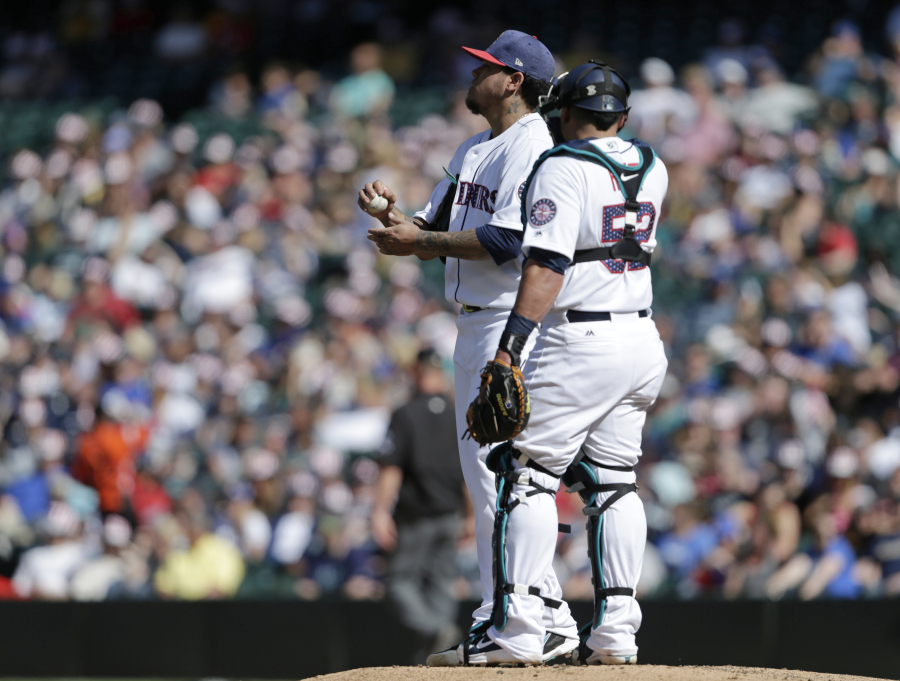 Seattle Mariners starting pitcher Felix Hernandez talks with catcher Carlos Ruiz after giving up a home run against the Kansas City Royals.