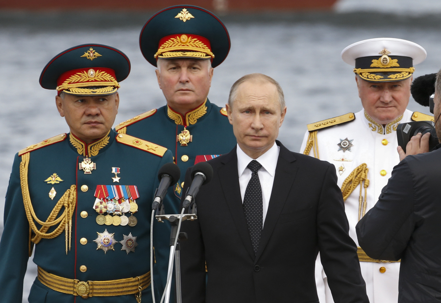 Russian President Vladimir Putin, center, Defence Minister Sergei Shoigu, left, Commander-in-Chief of the Russian Navy Vladimir Korolev, right, and Commander of Western military district Andrei Kartapolov arrive to attend the military parade during the Navy Day celebration in St.Petersburg, Russia, on Sunday.