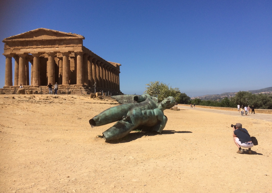This April 14, 2017 photo shows tourist Matthew Kirkland taking a photo of a bronze statue at the Valley of the Temples in Agrigento, Sicily, Italy. The seven Greek temples date to ancient times and have been declared a UNESCO World Heritage site.