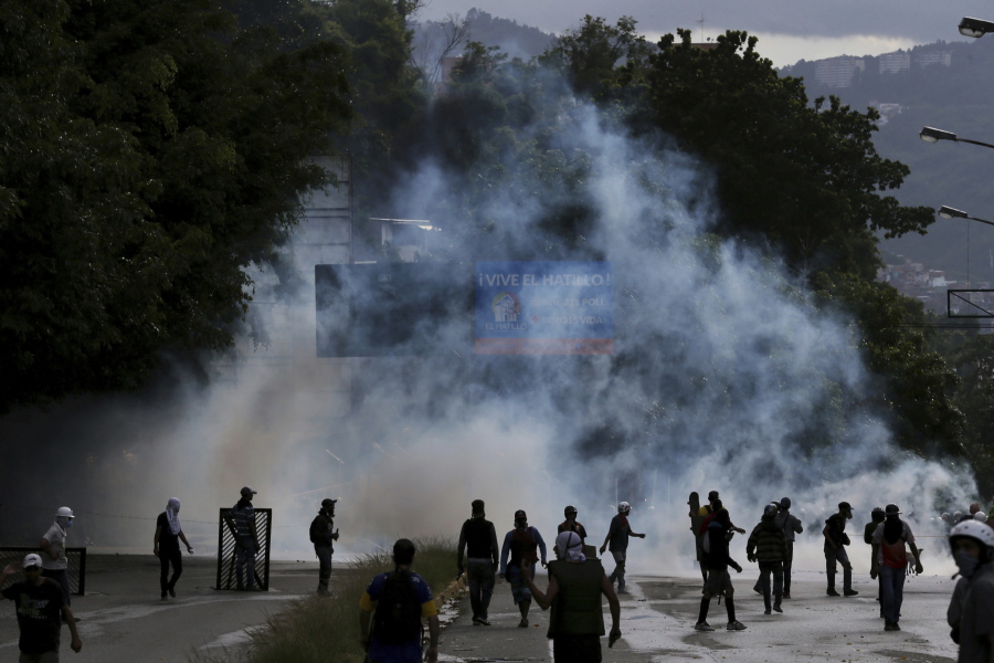 Demonstrators walk amid tear gas fired by Bolivarian National Guards during clashes in the El Hatillo neighborhood on the outskirts of Caracas, Venezuela, Thursday, July 20, 2017. Venezuelan President Nicolas Maduro and his opponents face a crucial showdown Thursday as the country’s opposition calls a 24-hour national strike.