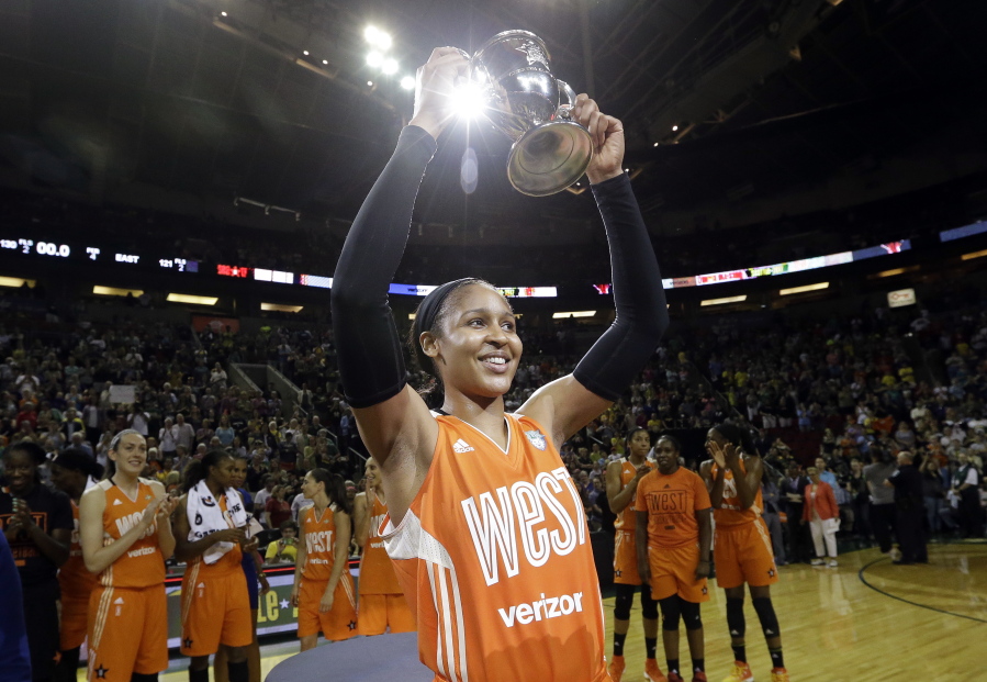 Minnesota Lynx’s Maya Moore, of the Western Conference, holds up a trophy after being named most valuable player as teammates cheer behind after the WNBA All-Star basketball game Saturday, July 22, 2017, in Seattle.(AP Photo/Elaine Thompson)