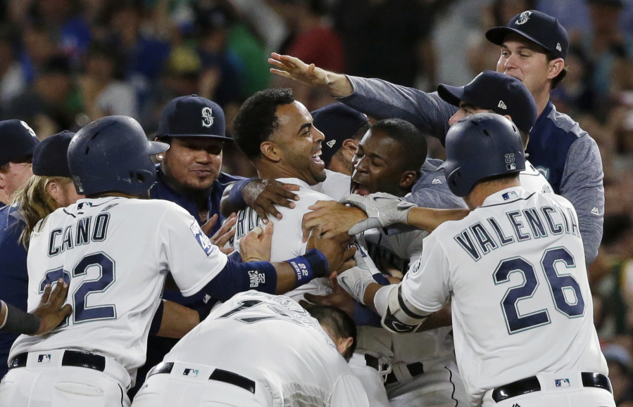 Seattle Mariners’ Nelson Cruz, center, is mobbed by teammates after he hit a walk-off single to score Ben Gamel during the 10th inning of the team’s baseball game against the New York Yankees, Saturday, July 22, 2017, in Seattle. The Mariners won 6-5. (AP Photo/Ted S.
