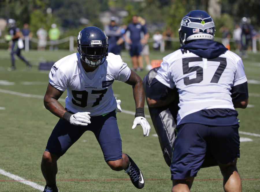 Seattle Seahawks defensive end Marcus Smith, left, lines up against linebacker Michael Wilhoite (57) during an NFL football training camp, Monday, July 31, 2017, in Renton, Wash. (AP Photo/Ted S.