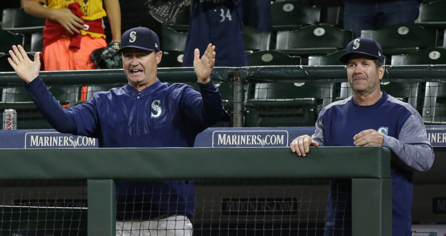 Seattle Mariners manager Scott Servais, left, and hitting coach Edgar Martinez, right, react as Mariners' Ben Gamel scores the tying run against the Boston Red Sox on a wild pitch from Doug Fister in the 13th inning of a baseball game, Wednesday, July 26, 2017, in Seattle. The Mariners won 6-5 in 13 innings. (AP Photo/Ted S.