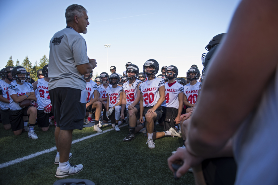 Camas High School coach Jon Eagle talks with his team at the beginning of their first practice in Camas on Wednesday evening, Aug. 16, 2017.