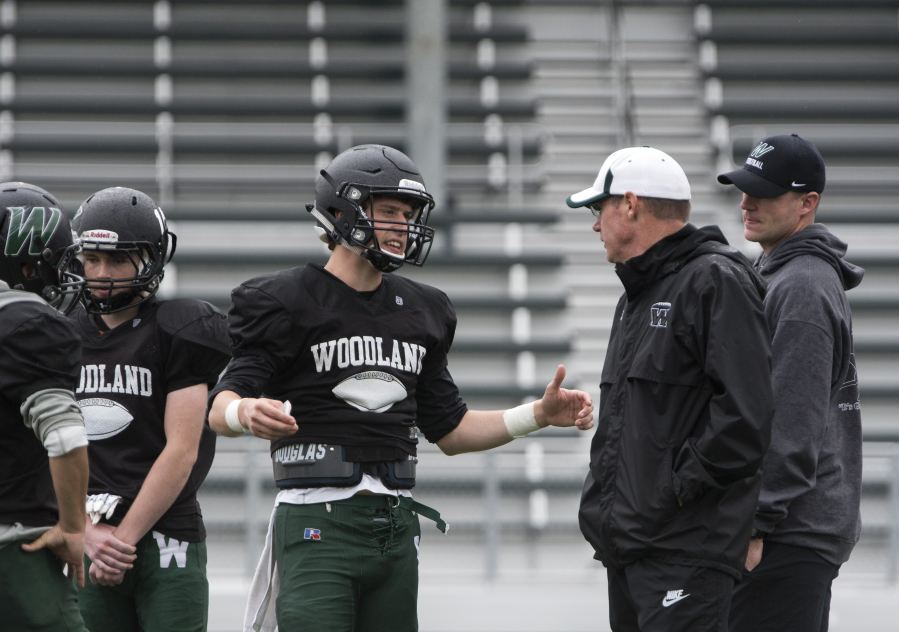 Woodland quarterback Wyatt Harsh talks with coach Mike Woodward. Harsh is the school’s all-time leading passer.