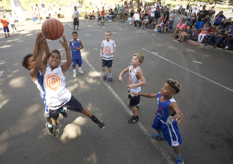 Savion McCoy reaches for a rebound in the 3rd grade division at the Hoops 360 3 on 3 outdoor basketball tournament featuring teams in grades 3-high school plus adult teams.