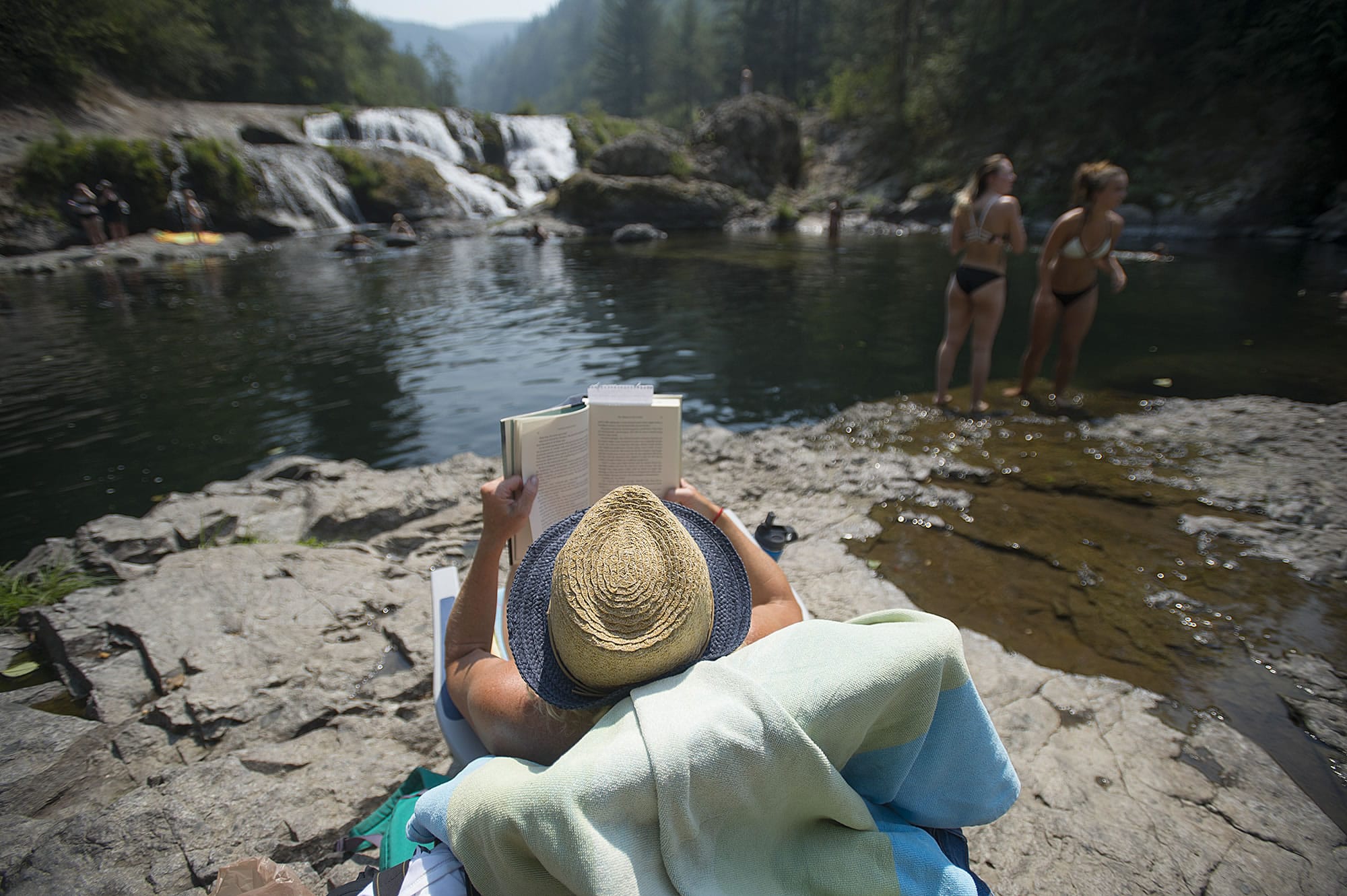 Jessica Magnusen of Tigard, center, relaxes with a good book and a scenic view with visiting Dougan Falls with her kids and friends Wednesday afternoon, Aug. 2, 2017.
