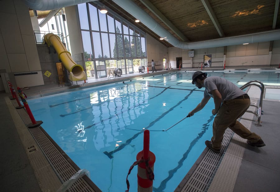 David Dayton of Anderson Poolworks cleans the bottom of the recently renovated Marshall Center pool on Friday morning.