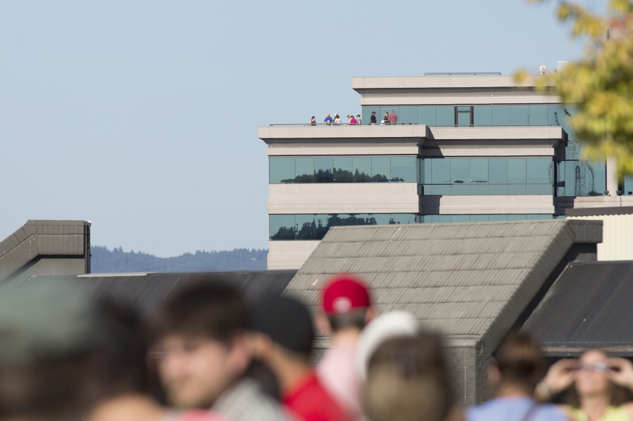 Spectators gather on the Vancouver Community Library terrace, foreground, and the First Independent Bank tower, rear, to view the eclipse.