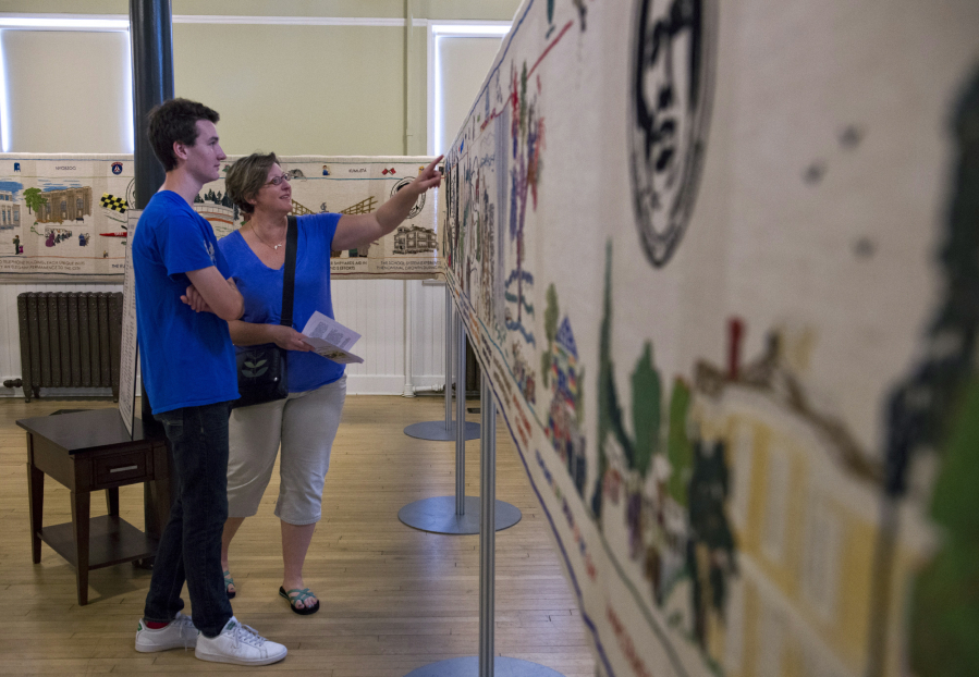 Andrew Douglas of Vancouver, 14, and his mother Sara Douglas discuss sections of the Fort Vancouver Tapestry at the Artillery Barracks on Tuesday. Sara had seen the tapestry when Andrew was younger and wanted to bring him back so they could look over it together.
