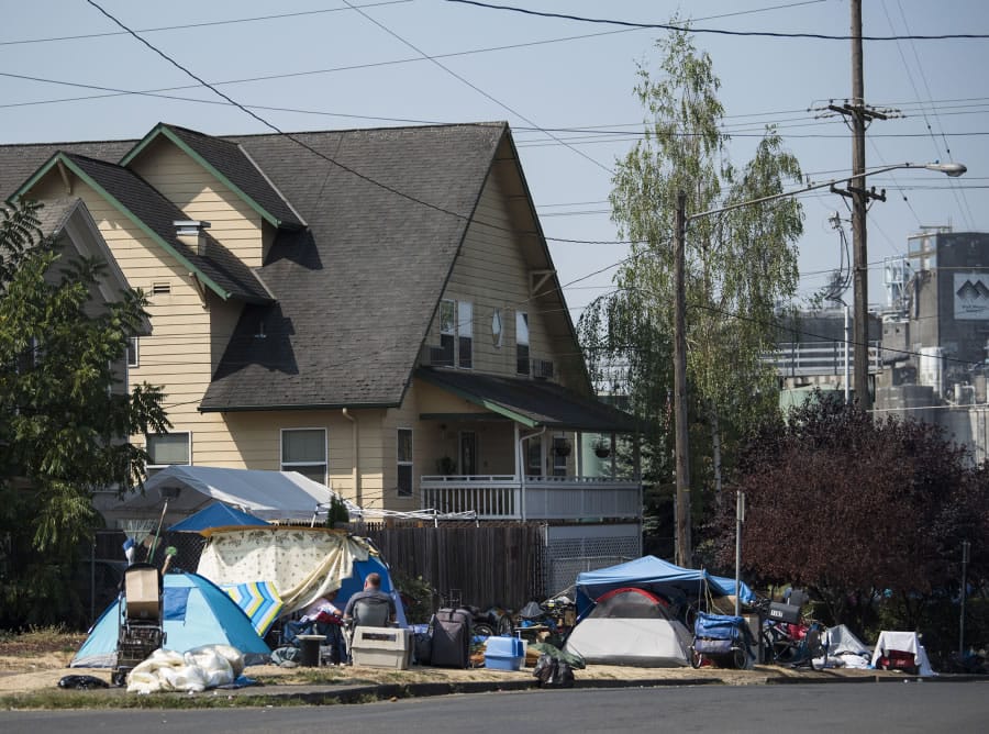 Tents and belongings line the street edge outside Share House, the men’s homeless shelter on the west edge of downtown Vancouver.