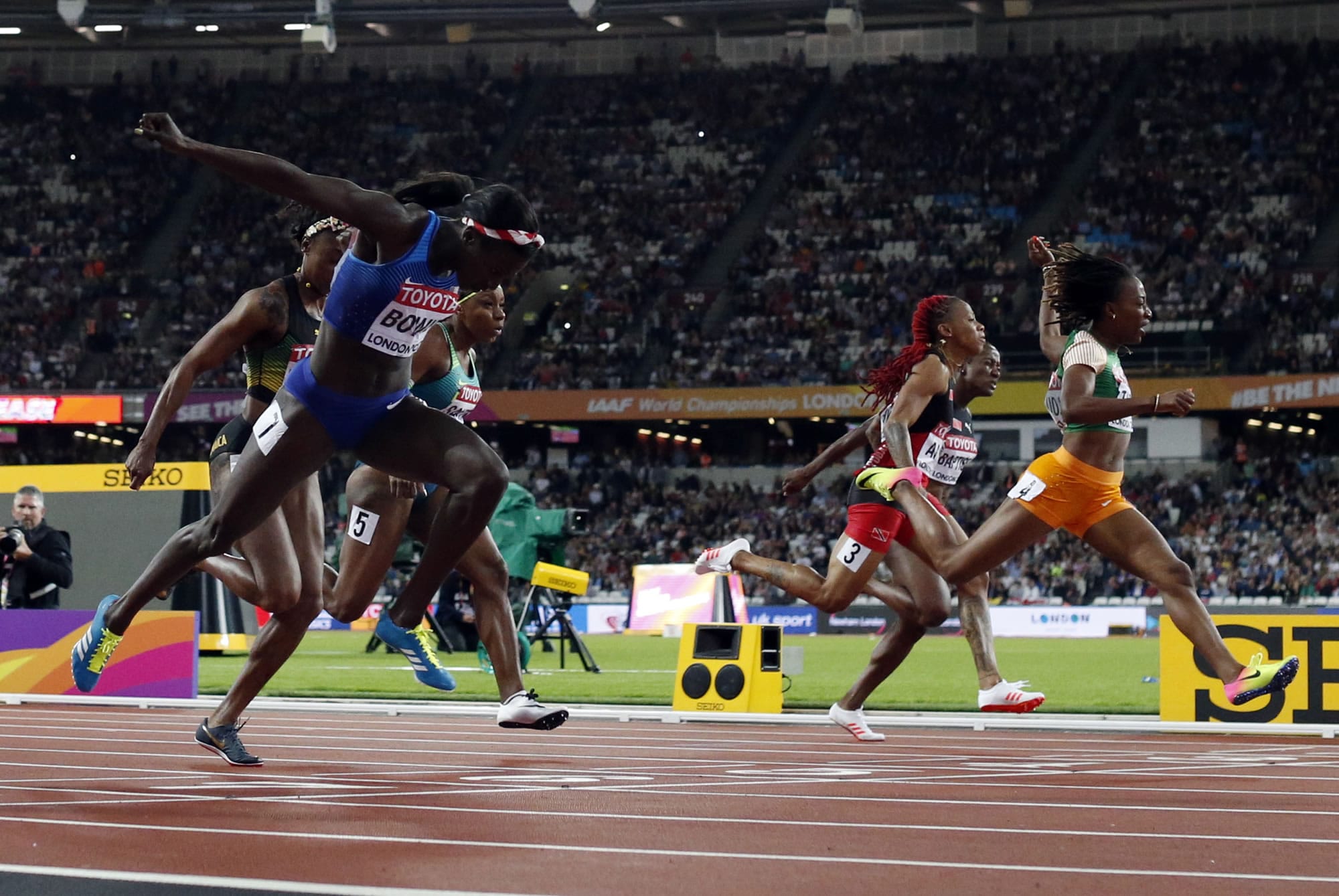 United States' Tori Bowie, left, crosses the line to win the gold in the women's 100-meter final during the World Athletics Championships in London Sunday, Aug. 6, 2017.