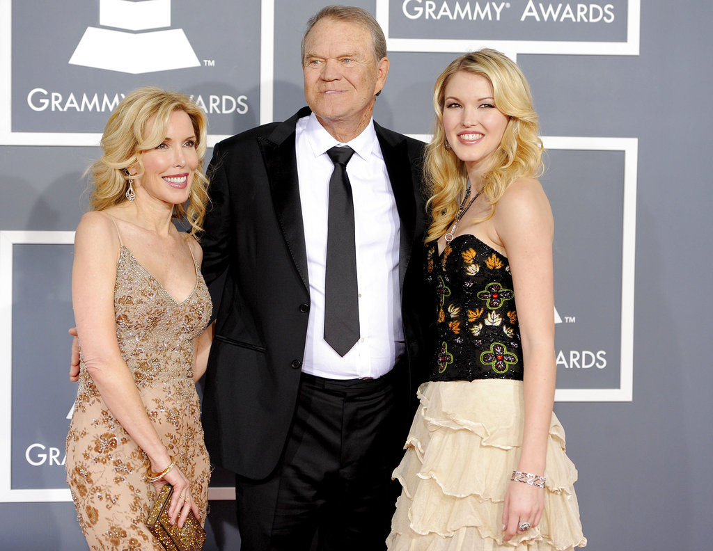 FILE - In this Feb. 12, 2012 file photo, Glen Campbell, center, Kim Woolen, left, and Ashley Campbell arrive at the 54th annual Grammy Awards in Los Angeles. Campbell, the grinning, high-pitched entertainer who had such hits as "Rhinestone Cowboy" and spanned country, pop, television and movies, died Tuesday, Aug. 8, 2017. He was 81. Campbell announced in June 2011 that he had been diagnosed with Alzheimer's disease.