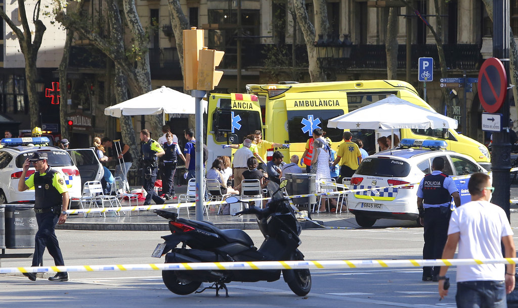 Injured people are treated in Barcelona, Spain, Thursday, Aug. 17, 2017 after a white van jumped the sidewalk in the historic Las Ramblas district, crashing into a summer crowd of residents and tourists and injuring several people, police said.