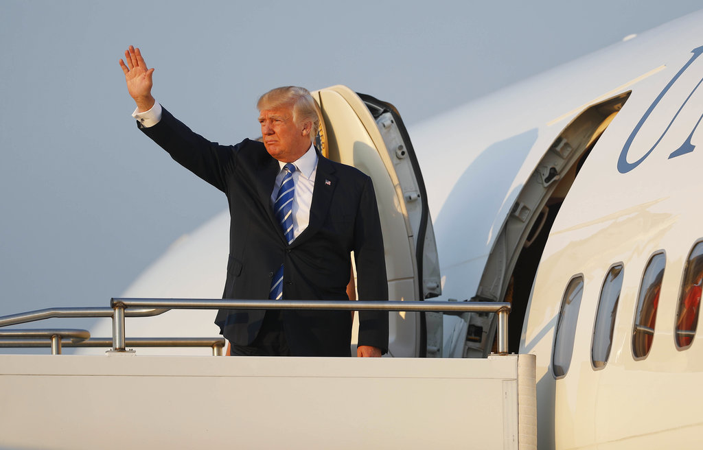 President Donald Trump waves while boarding Air Force One at Morristown Municipal Airport, Sunday, Aug. 20, 2017, in Morristown, N.J., for the return flight to the Washington area.