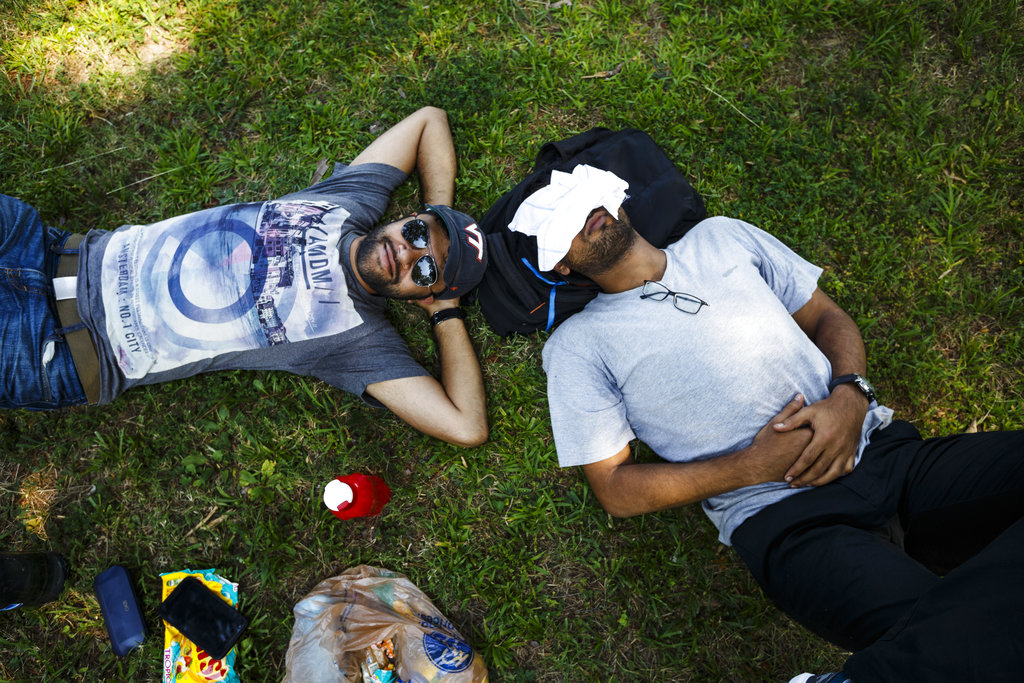 Abhinaba Nandy, left, and Shibaji Chakraborty, who traveled from Virginia Tech, nap in Veteran's Park as they wait for the start of the total solar eclipse on Monday, Aug. 21, 2017, in Spring City, Tenn.