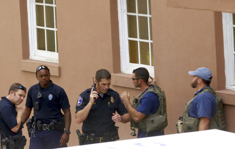 Police gather near the scene of a reported shooting in Charleston, S.C., on Thursday, Aug.24, 2017.  Authorities say a disgruntled employee shot one person and is holding hostages in a restaurant in an area that is popular with tourists. Mayor John Tecklenburg said at a news conference that the shooting was not an act of terrorism or racism.