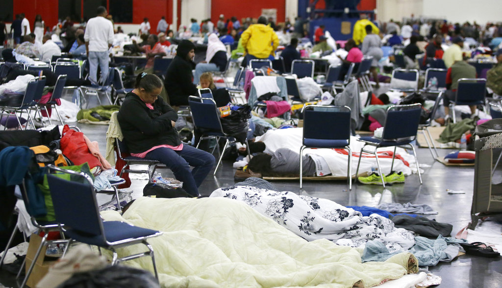 People rest at the George R. Brown Convention Center that has been set up as a shelter for evacuees escaping the floodwaters from Tropical Storm Harvey in Houston on Tuesday, Aug. 29, 2017.