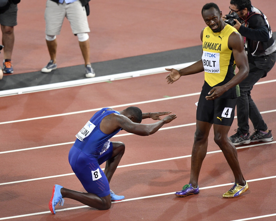 Justin Gatlin, ganador de la medalla de oro, se arrodilla frente a Usain Bolt, ganador del bronce, tras la final de los 100 metros en el Mundial de atletismo, en Londres, el sábado 5 de agosto de 2017.