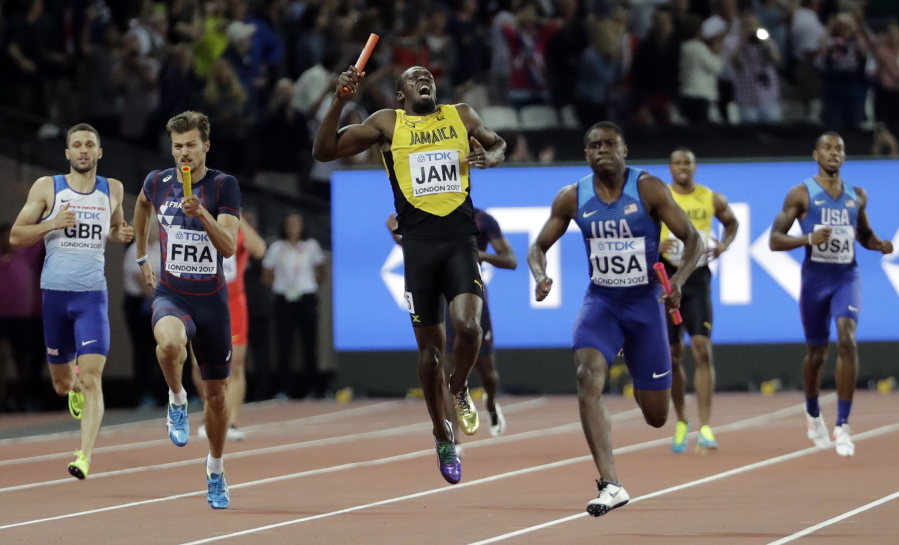 Jamaica's Usain Bolt, center, pulls up injured in the final of the Men's 4x100m relay during the World Athletics Championships in London Saturday, Aug. 12, 2017. At right is United States' Christian Coleman. (AP Photo/David J.