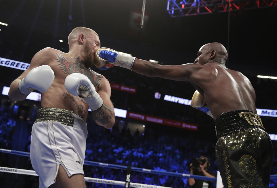 Floyd Mayweather Jr. connects to the face of Conor McGregor during their super welterweight match Saturday at Las Vegas.