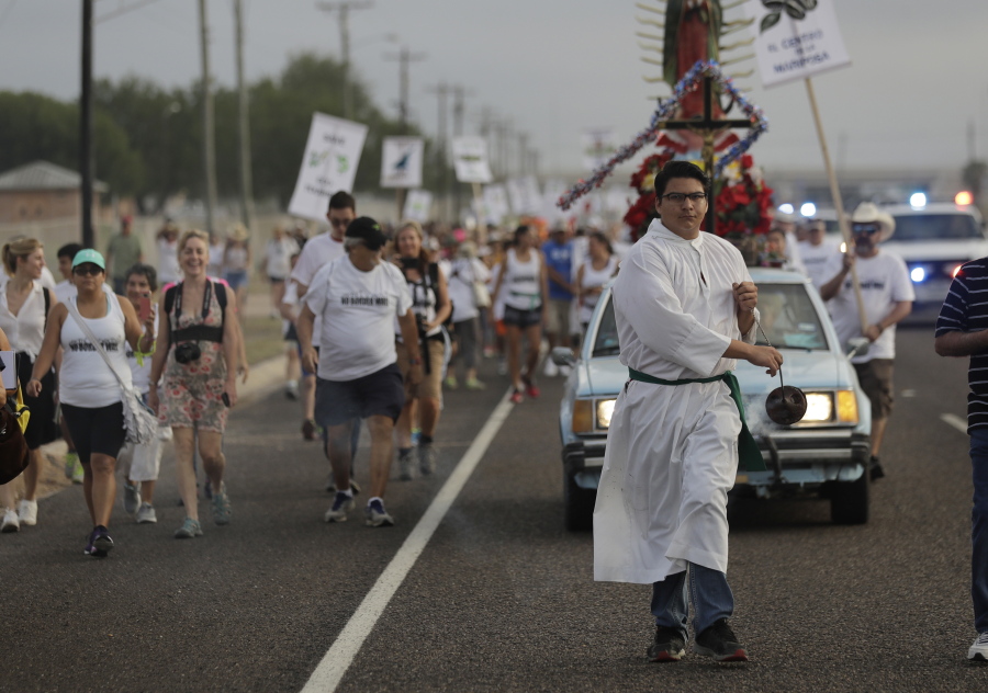 Alter server Anthoney Saenz waves incense as he helps lead a procession toward the Rio Grande Saturday in Mission, Texas, to oppose the wall the government wants to build on the river separating Texas and Mexico. The area would be the target of new barrier construction under the Trump administration’s plan.