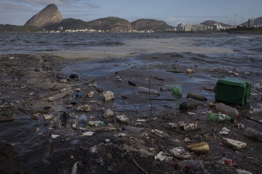 Trash floats in Guanabara Bay on Saturday in Rio de Janeiro, Brazil. Environmental activists sailed across the bay to protest pollution in the Brazilian city’s waterways. Sugar Loaf Mountain is in the background.