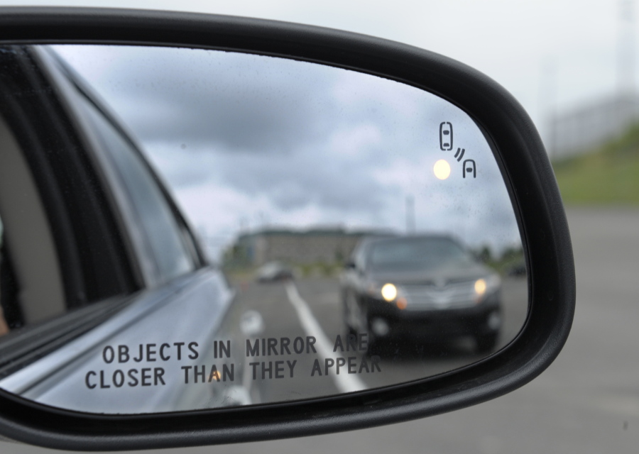 FILE - In his May 22, 2012 file photo, a side mirror warning signal in a Ford Taurus at an automobile testing area in Oxon Hill, Md. Safety systems to prevent cars from drifting into another lane or warn drivers of vehicles in their blind spots are beginning to live up to their potential to significantly reduce crashes, according to two studies released Wednesday, Aug. 23, 2017.