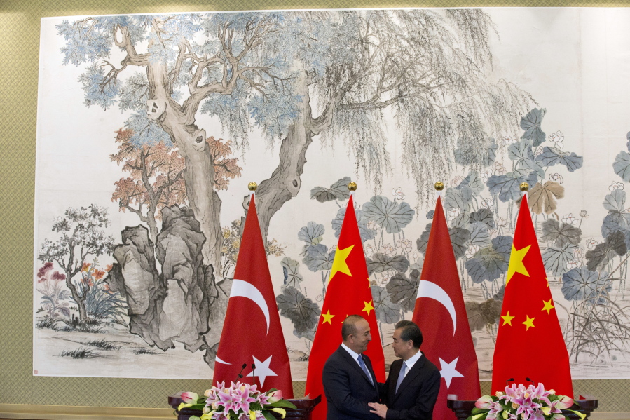 Chinese Foreign Minister Wang Yi at right shakes hands with Turkish Foreign Minister Mevlut Cavusoglu after a joint press conference held at the Diaoyutai State Guesthouse in Beijing, China, on Thursday.