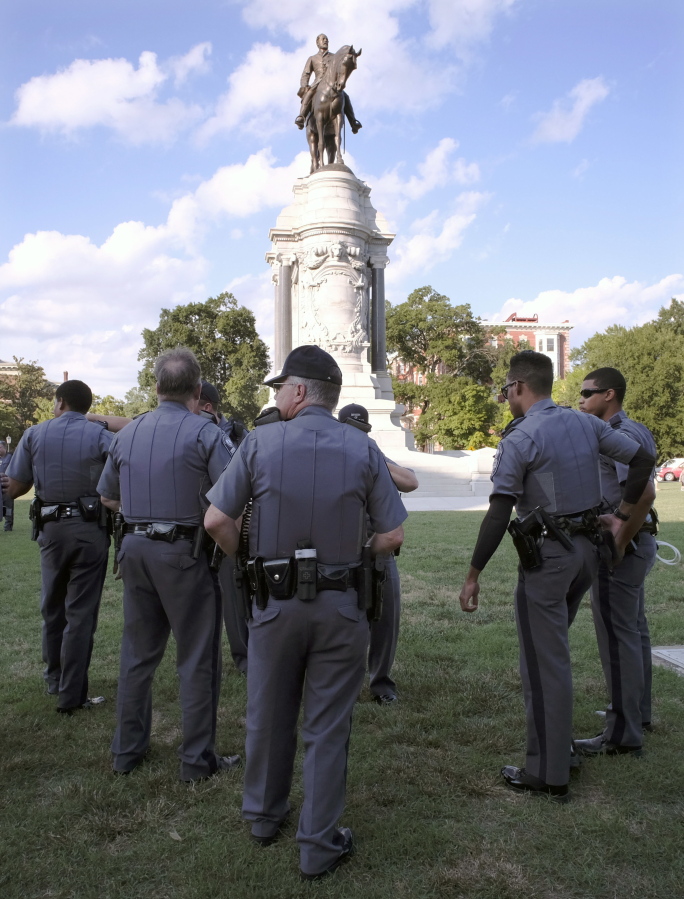 Capitol Police officers are posted Friday around a statue of Confederate Gen. Robert E. Lee in Richmond, Va.