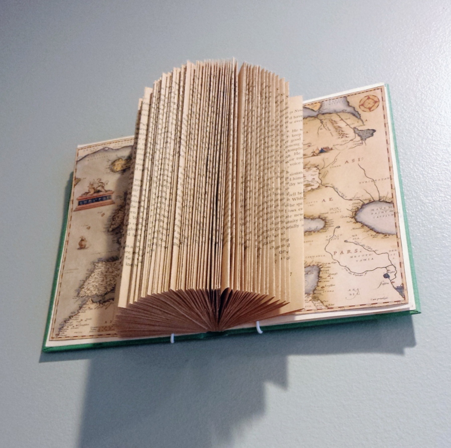 This undated photo provided by Candice Caldwell shows book folding projects hanging on the wall of her Chicago home.